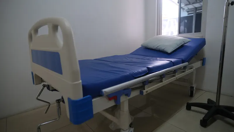 Ruang observasi di Klinik Pratama Waluya Sentosa, dengan bed rawat berbantal dan tiang infus di sampingnya, digunakan juga untuk menangani pasien Trauma Center/PLKK. Ruangan bersih, terang, dan tenang.